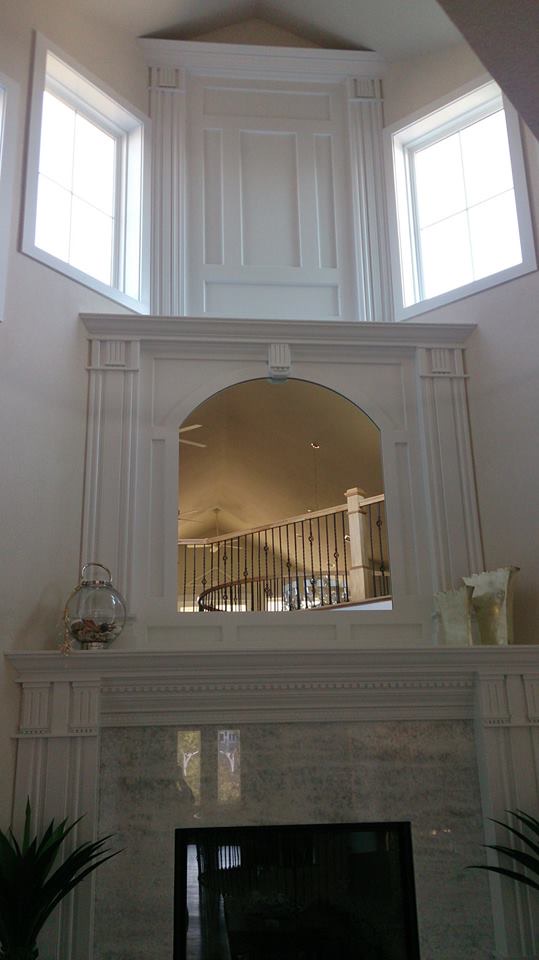 Two-story custom fireplace mantel with paneled overmantel